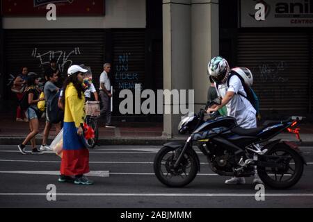 Young protester makes motorbike driver turn around during traffic blocking. Peaceful protests continue one week after the nationwide strike in Cali, C Stock Photo