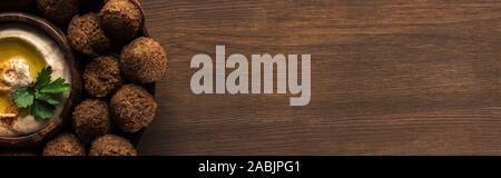 top view of falafel balls with hummus on plate on wooden table with copy space, panoramic shot Stock Photo