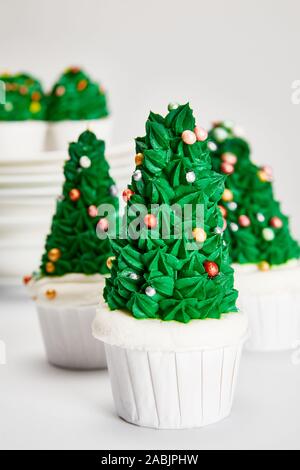 delicious Christmas tree cupcakes on white surface isolated on grey Stock Photo