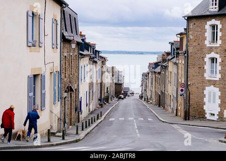 A view down Rue du Port in the fishing town of Cancale, Brittany, looking towards the sea and St-Benoît-des-Ondes. Stock Photo