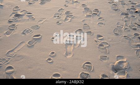 Prints From Various Footwear on Sand. Urban Background. Texture of Yellow Sand With Traces of Different Shoes. Stock Photo