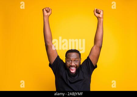 Photo of excited overjoyed rejoicing man expressing crazy emotions on face in eye glasses raising his fists up after winning tickets to go abroad on Stock Photo