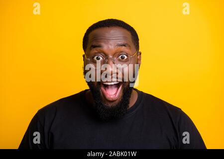 Close up photo of ecstatic overjoyed man rejoicing in sales started with excitement on face shouting with spectacles in t-shirt isolated vibrant color Stock Photo