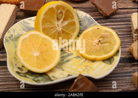 sliced lemon on a saucer and on a wooden background. Close up Stock Photo