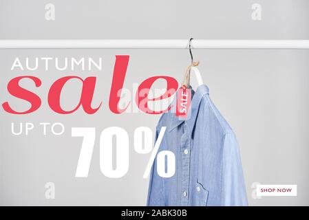 blue shirt hanging with sale label isolated on white with autumn sale, up to 70 percent illustration Stock Photo