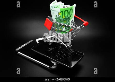 Euro banknotes and smartphones on a black background. Stock Photo