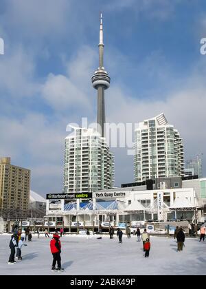 People ice skating on ice rink at Harbourfront Centre and CN Tower in Toronto, Ontario, Canada Stock Photo