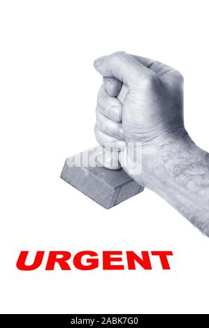 male hand with a rubber stamp over white background stamping the word Urgent Stock Photo