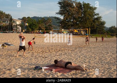 18.11.2019, Phuket, Thailand, Asia - A group of tourists plays volleyball at dusk on Karon Beach. Stock Photo