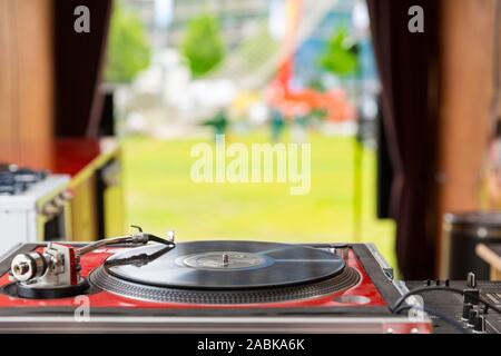 Eindhoven, The Netherlands, May 5th 2017. A close up of a dj table in a old retro bus with a grass field and a festival in the background on a sunny d Stock Photo