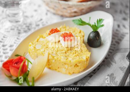 Egg and cheese salad is decorated with quail eggs and caviar. Restaurant serving. Copy space. Selective focus. Stock Photo