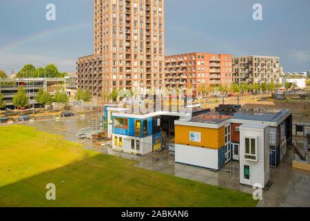 Strijp S Eindhoven, August 13th 2018. A view on Plug-in City with a part of the ketelhuisplein grassfield and new Strijp S buildings and a rainbow in Stock Photo