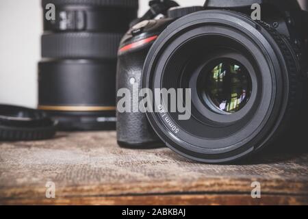 Close up of a black DSLR camera with a 50mm 1.8G prime lens on an old brown wooden vintage box surface. Photographer's photographic equipment. Stock Photo