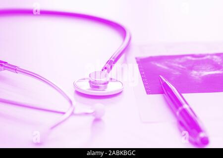 Medical desk on lilac backround with stethoscope, pen and fluoroscopic image, close up. Horizontal photo Stock Photo