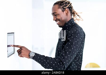 African man using smart home screen control system Stock Photo