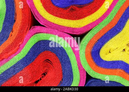 Close up coils of colorful crepe paper bunting of red, orange, yellow, green, blue and pink to make an abstract background Stock Photo