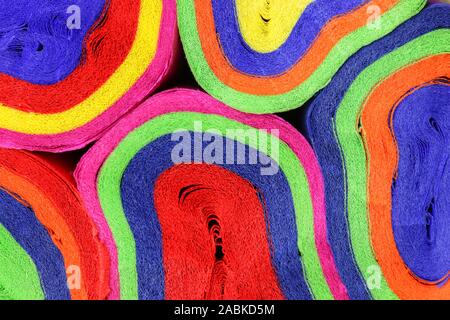 Close up coils of colorful crepe paper bunting of red, orange, yellow, green, blue and pink to make an abstract background Stock Photo