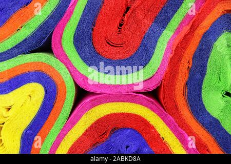 Close up coils of colorful crepe paper bunting of red, orange, yellow, green, blue and pink to make an abstract background Stock Photo