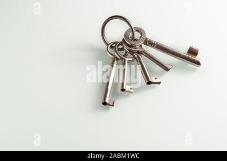 Closeup of a bunch of old keys lying on a white glass plate Stock Photo
