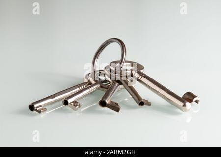 Closeup of a bunch of old keys lying on a white glass plate Stock Photo