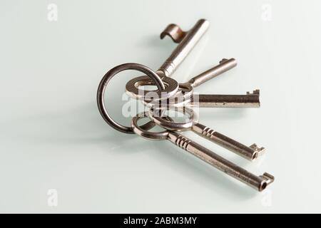 Closeup of a bunch of old keys lying on a white glass plate Stock Photo