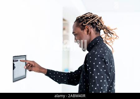 African man using smart home screen control system Stock Photo