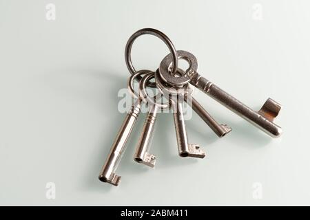 Closeup of a bunch of old keys lying on a white glass plate Stock Photo