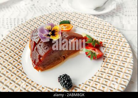 An English cake in a baking dish on a wooden board and a white wooden  table. Selective focus Stock Photo - Alamy