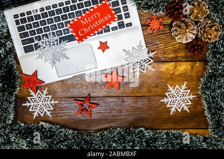 Merry Christmas wooden sign on keyboard. Christmas decorations on wooden table. Christmas concept. Stock Photo