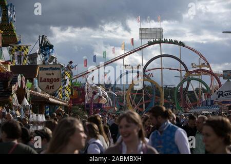 Crowd and roller coaster Olympic looping on the Munich Wiesn