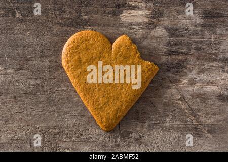 Broken Heart shaped cookie on wooden table. Valentine's Day and Mother's Day concept. Top view. Stock Photo