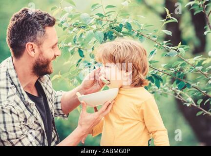 Nutrition for kids and adults. Healthy nutrition concept. Feeding baby. Menu for children. Family enjoy homemade meal. Father son eat food and have fun. Nutrition habits. Little boy and dad eating. Stock Photo