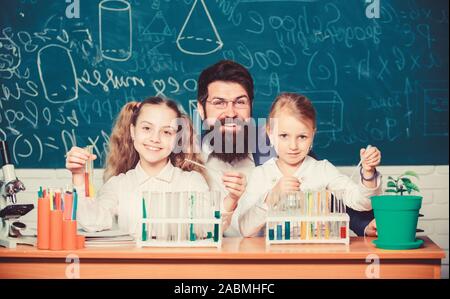 School biology experiment. Explaining biology to children. How to interest children study. Fascinating biology lesson. Man bearded teacher work with microscope and test tubes in biology classroom. Stock Photo
