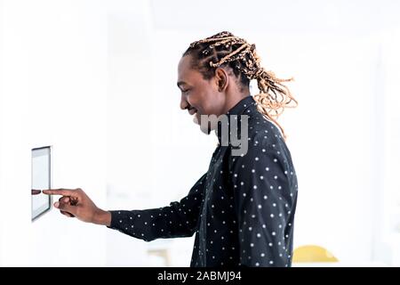 African man using smart home screen control system Stock Photo