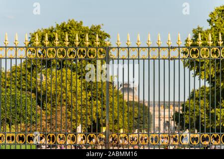 View of a heavy black wrought iron fence topped with golden spikes at the entrance of the Tuileries gardens  in Paris, France Stock Photo