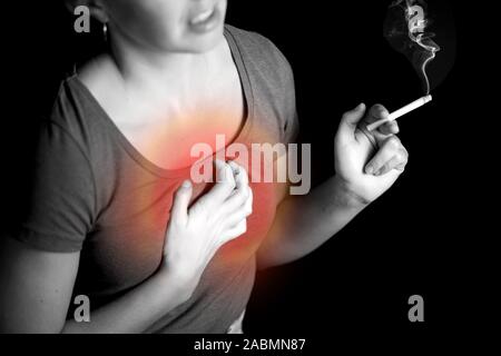 Woman smokes cigarette and has problem with lungs or heart attack. Nicotine addiction concept Stock Photo