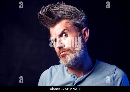 A portrait of bearded man with surprised face in front of black background Stock Photo