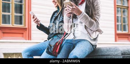 Young friends using mobile smartphone outdoor - Young people addicted to new technology trends app for social media Stock Photo