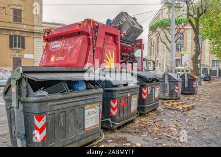 Rome, Italy garbage truck collecting waste disposal. Municipal AMA trash vehicle on the streets of the Roman capital, loading full dumpsters. Stock Photo