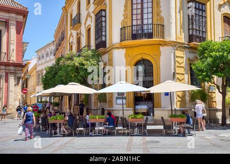 People enjoying outdoor sidewalk cafes in Santa Cruz or old Jewish Quarter of Seville Andulsia Spain Stock Photo