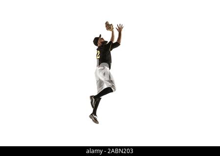 In jump. Baseball player, pitcher in black uniform practicing and training isolated on white background. Young professional sportsman in action and motion. Healthy lifestyle, sport, movement concept. Stock Photo