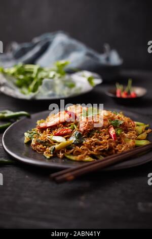 Stir-fry. Delicious cooked noodles with chicken in bowl, soy sauce ...