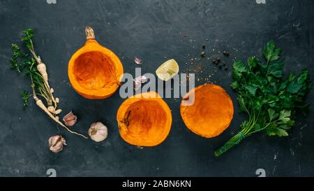 Hokkaido pumpkin is cut in half, spices, herbs. Baked pumpkin recipe. Stock Photo
