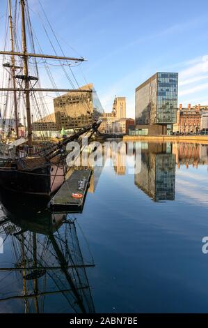 Vertical shot of Tall Ship and modern office buildings surrounding Canning Dock redevelopment in Liverpool. Beautiful reflections in the water on a su Stock Photo