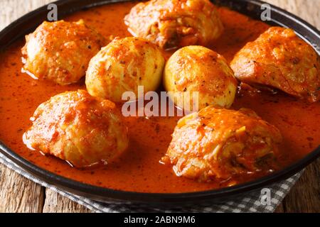 African Doro Wat from chicken thighs with eggs in a spicy sauce close-up in a plate on the table. horizontal Stock Photo