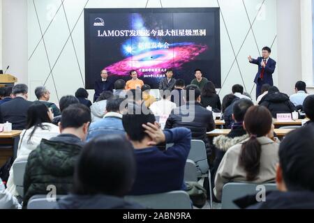 (191128) -- BEIJING, Nov. 28, 2019 (Xinhua) -- Liu Jifeng (1st R Back), deputy director-general of the National Astronomical Observatory of the Chinese Academy of Sciences (NAOC) and the first author of the study, speaks during a press conference of the black hole LB-1 discovered with the Large Sky Area Multi-Object Fibre Spectroscopy Telescope (LAMOST), in Beijing, capital of China, Nov. 27, 2019. A Chinese-led research team has discovered a surprisingly huge stellar black hole about 14,000 light years from Earth -- our 'backyard' of the universe -- forcing scientists to re-examine how such b Stock Photo