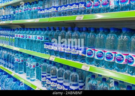 TASHKENT, UZBEKISTAN - MAY 12, 2019: Bottles with mineral water displayed on the shelf in supermarket