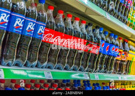 TASHKENT, UZBEKISTAN - MAY 12, 2019: Bottles with popular carbonated soft drinks displayed on the shelf in supermarket