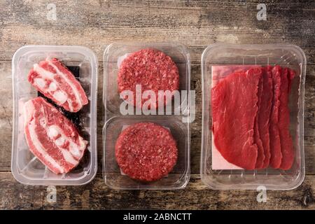 Different types of meat packaged in plastic on wooden table. Top view Stock Photo
