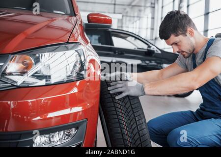 A mechanic with a tire bus in a repair garage. replacement of winter and summer tires Stock Photo